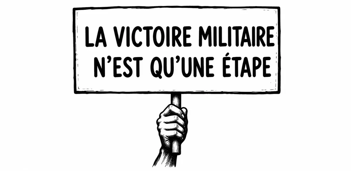 Une main tient une pancarte portant le message : La victoire militaire n’est qu’une étape